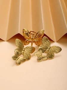 Detailed view of vintage gold butterfly jewelry set on an elegant paper fan background