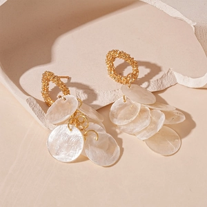 Resort style round faux shell tassel earrings with golden textured studs and white discs