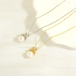 Golden and silver crown necklaces with colorful gems and freshwater pearls on shell