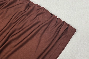 Détail du tissu en maille marron chocolat avec plis serrés et doubles surpiqûres robustes