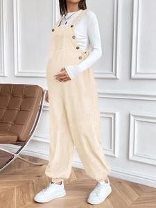 Detail view of adjustable side buttons and corduroy texture on maternity overalls