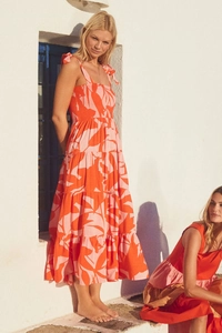 Detail of elegant orange floral sleeveless backless dress with layered ruffled hemline