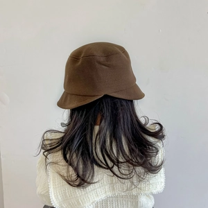 Gros plan sur la texture du chapeau cloche en maille marron et les bords souples