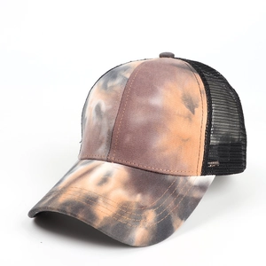 Detail of tie-dye trucker hat featuring orange-black patterns and breathable mesh back