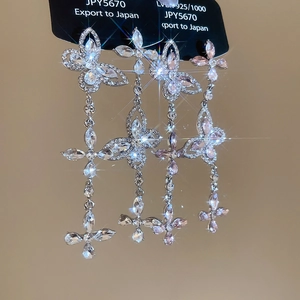 Detail of 925 silver tassel earrings with butterfly cubic zirconia and sparkling star effect
