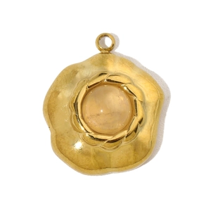 Macro shot of gold-plated stainless steel flower pendant with orange natural stone