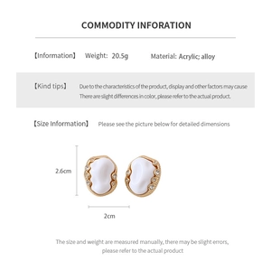 Detailed view of vintage oval earrings with gold frames and white acrylic texture