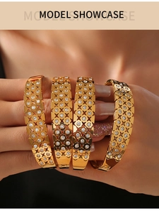 Detail of stacked gold hollow grid bracelets featuring white cubic zirconia stones