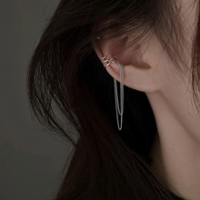 Silver wrap snake cuff earring with long tassel chains shown on a model's ear