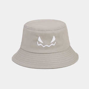 Detailed close-up of white ghost face embroidery on a grey cotton bucket hat