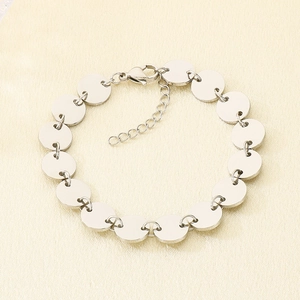 Detailed top view of silver disc bracelet featuring polished stainless steel and lobster clasp