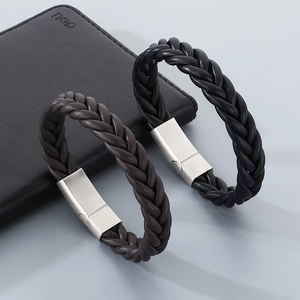 Detail of woven leather bracelets with brushed magnetic metal clasps on a wallet