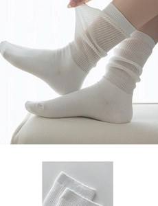 Close-up of white ribbed knit cotton crew socks showing breathable texture and elastic cuff
