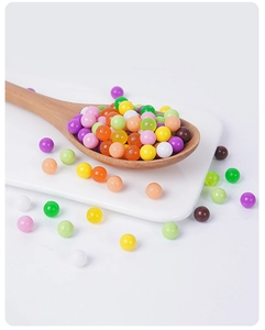 Close-up of colorful resin beads in a wooden spoon used as DIY dessert decoration