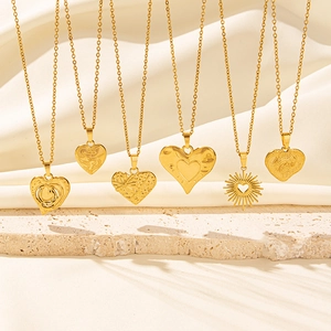 Collection of six unique 18k gold plated heart pendant necklaces on stone and silk