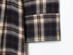 Detail view of the flannel plaid fabric and stitched cuff of the retro long shirt dress