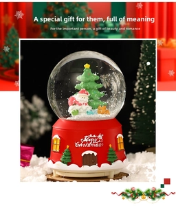 Detailed view of a Christmas snow globe with Santa and reindeer on a festive red base