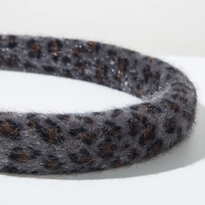 Detailed close-up of fluffy leopard print headband with soft faux fur texture and fabric
