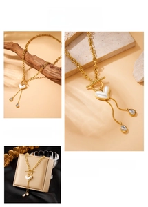 Detail of gold-plated stainless steel OT-clasp necklace with pearl heart and fringe drop