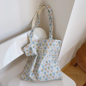 Détail du sac cabas en toile à fleurs jaunes et étiquette de motifs naturels