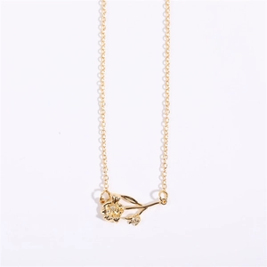 Vertical flat lay of an 18K gold plated necklace featuring a detailed flower pendant