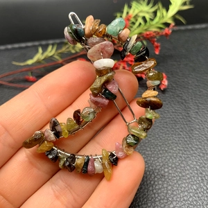 Detail of moon-shaped hair clip with handcrafted multicolor natural crystal stones