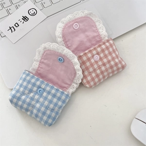 Close-up of quilted fabric earphone pouches with elegant white lace trim and button