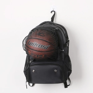 Detail showing front elastic mesh pocket holding a basketball on the black sports backpack