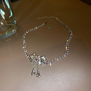 Détail du collier noeud argenté avec cristaux étincelants et pendentifs en goutte