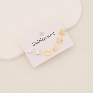 Detail of three pairs of stainless steel earrings featuring butterfly and petal designs