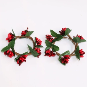 Set of two festive red berry candle rings with green leaves for table decoration