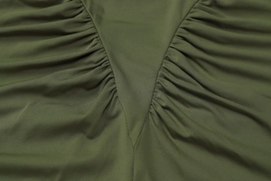 Close-up of dark green pleated fabric featuring detailed stitching and ruched texture details