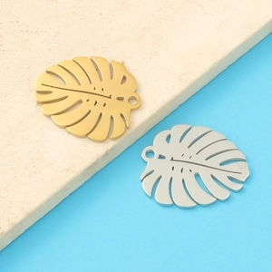 Detailed view of gold and silver monstera leaf pendants for DIY jewelry making