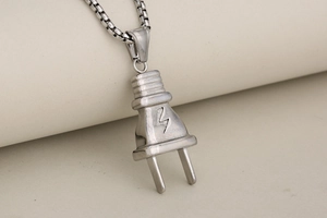 Macro view of silver plug pendant with lightning bolt symbol on a metal box chain