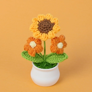 Handgemaakte gehaakte zonnebloem en oranje bloemen in witte pot voor tafeldecoratie