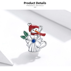 Detail of S925 silver Christmas snowman charm with red enamel hat and blue gemstone