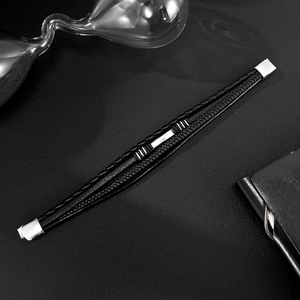 Men's multilayer black braided leather bracelet with silver steel clasp on black background