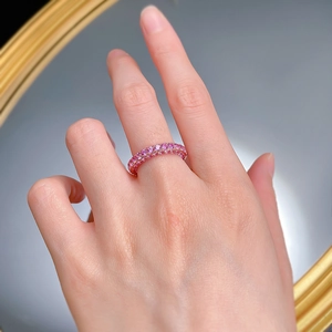 Close-up of luxury double-row pink gemstone ring with polished gold band on a hand