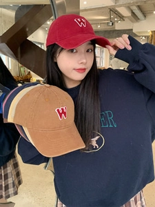 Detailed embroidery of letter W on multiple cotton baseball caps in vibrant colors