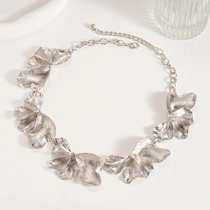Detailed view of silver metallic ginkgo leaf necklace with textured petal elements