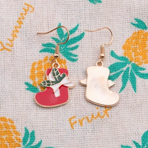 Detail of red enamel Christmas stocking earrings with white bow and gold fishhook hooks