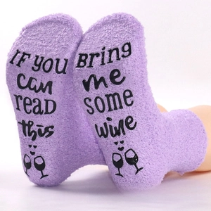 Detail of purple coral fleece socks featuring anti-slip letter print on the soles