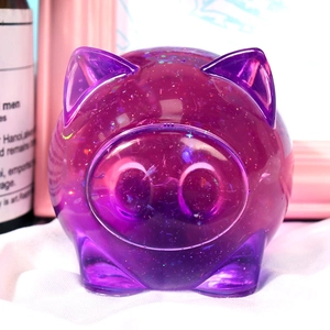 Macro shot of a purple translucent resin pig figurine with sparkling glitter finish