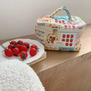 Detail of quilted cotton cosmetic bag with cute patchwork patterns and top handle
