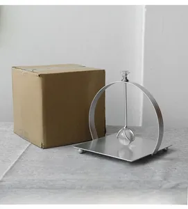 Detail of silver metal napkin holder with crystal weighted arm and secure packaging box