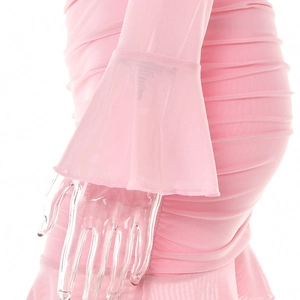 Détail de robe en tulle rose avec poignets évasés et texture plissée sur tissu transparent