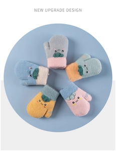 Close-up of knit winter mittens with cute carrot embroidery and cozy fleece lining
