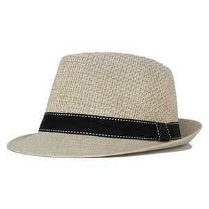 Close-up of beige summer straw fedora with breathable weave and black decorative ribbon
