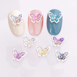 Macro shot of 3D gradient butterfly nail charms with aurora effect and silver metal frame