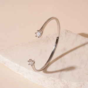 Minimalist silver-tone C-shape open bangle with zircon stone inlays on textured stone tray